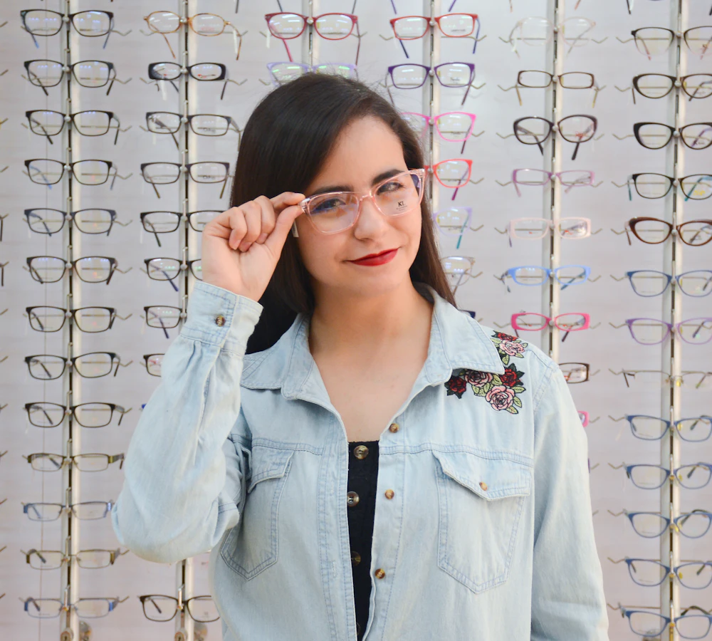 Clienta probándose lentes ópticos frente a una vitrina de marcos
